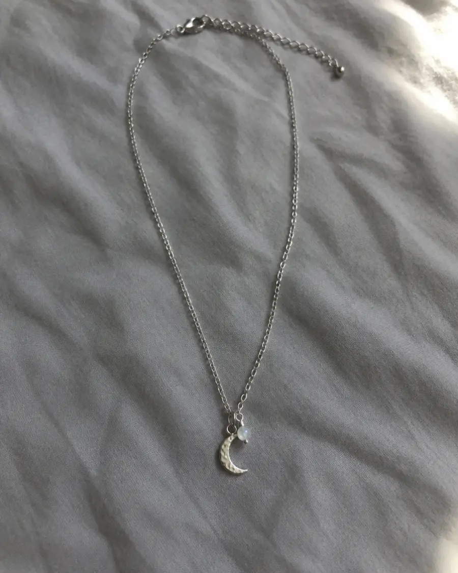 Phone photo of a necklace on a bedsheet